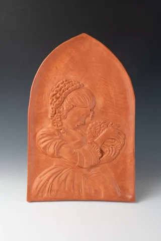 Bas relief of an 18th century woman looking at a brain.
