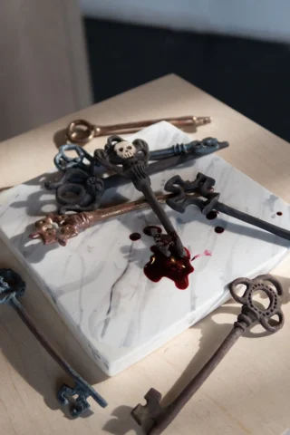 A mess of keys on a marble slab, all ceramic except the blood.